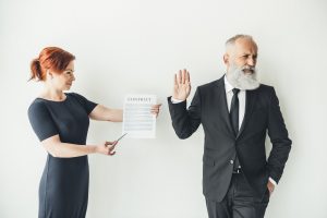 woman holding business contract and businessman refusing to sign it