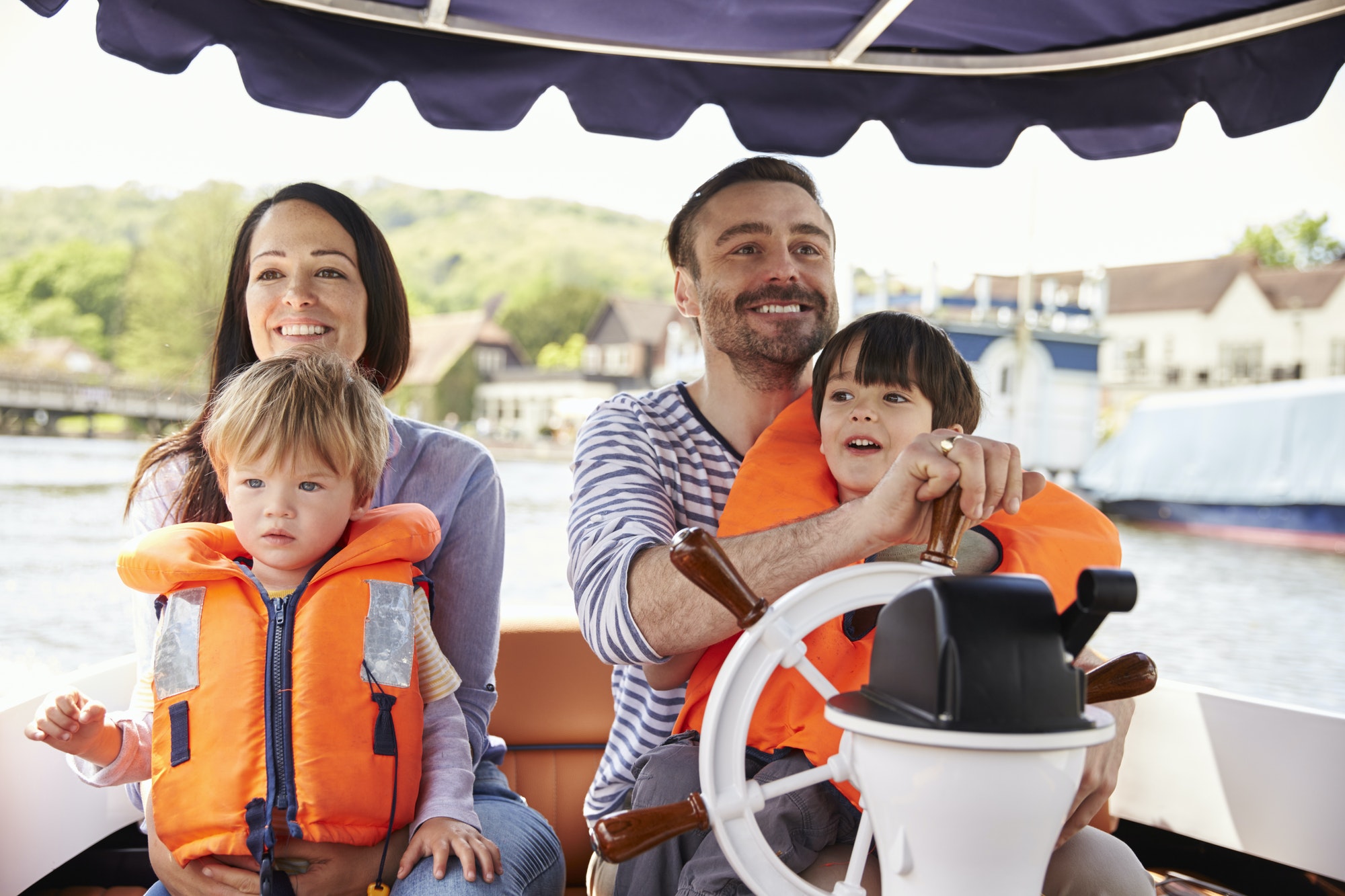 Family Enjoying Day Out In Boat On River Together